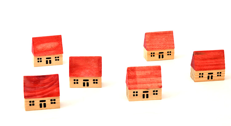 Wooden model houses in red, representing real estate or mortgage industry.