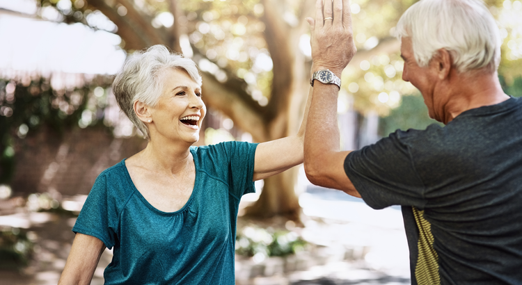Happy senior couple high-fiving, symbolizing the joy and financial security of well-planned retirement.