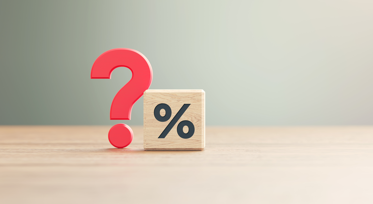 Wooden block with a percentage symbol next to a red question mark, symbolizing uncertainty about mortgage rates.