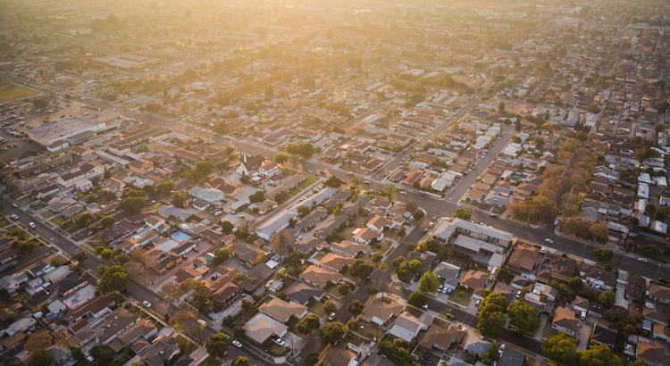 Aerial view of a suburban neighborhood at sunset, symbolizing housing market forecasts.