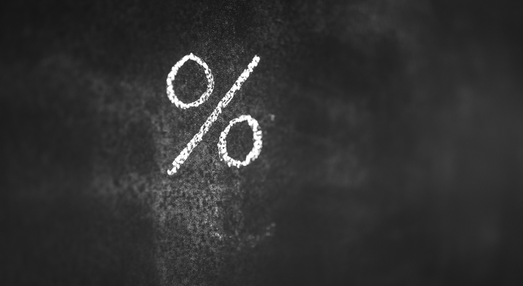 Chalk-drawn percentage symbol on a blackboard, symbolizing interest rates and financial calculations.