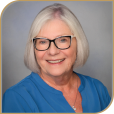 Ann smiling warmly in a professional headshot.