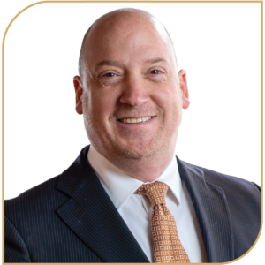 Grant Eggleston in a suit and tie, smiling warmly in a professional headshot.