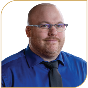Josh Hitsman smiling confidently in a blue shirt with glasses.