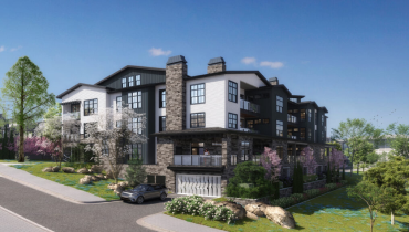 Exterior view of a modern multi-unit residential building with stone and siding.