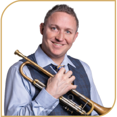 Aidan Donohue – Mortgage Specialist and Music Enthusiast at Directors Mortgage Aidan Donohue smiling confidently while holding a trumpet, dressed in a vest and tie.